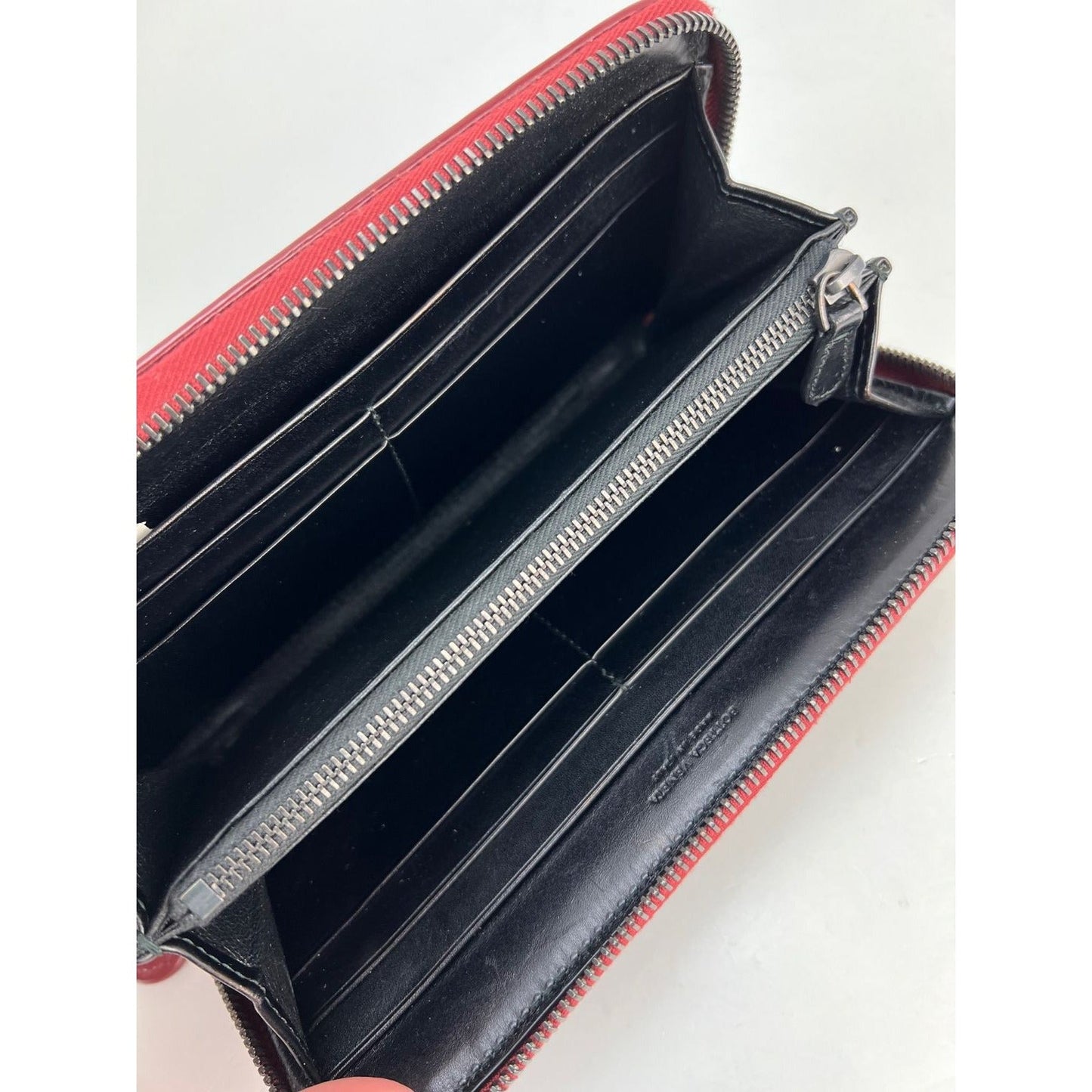 Pochette portefeuille zippée en cuir bordeaux Intrecciato de Bottega Veneta