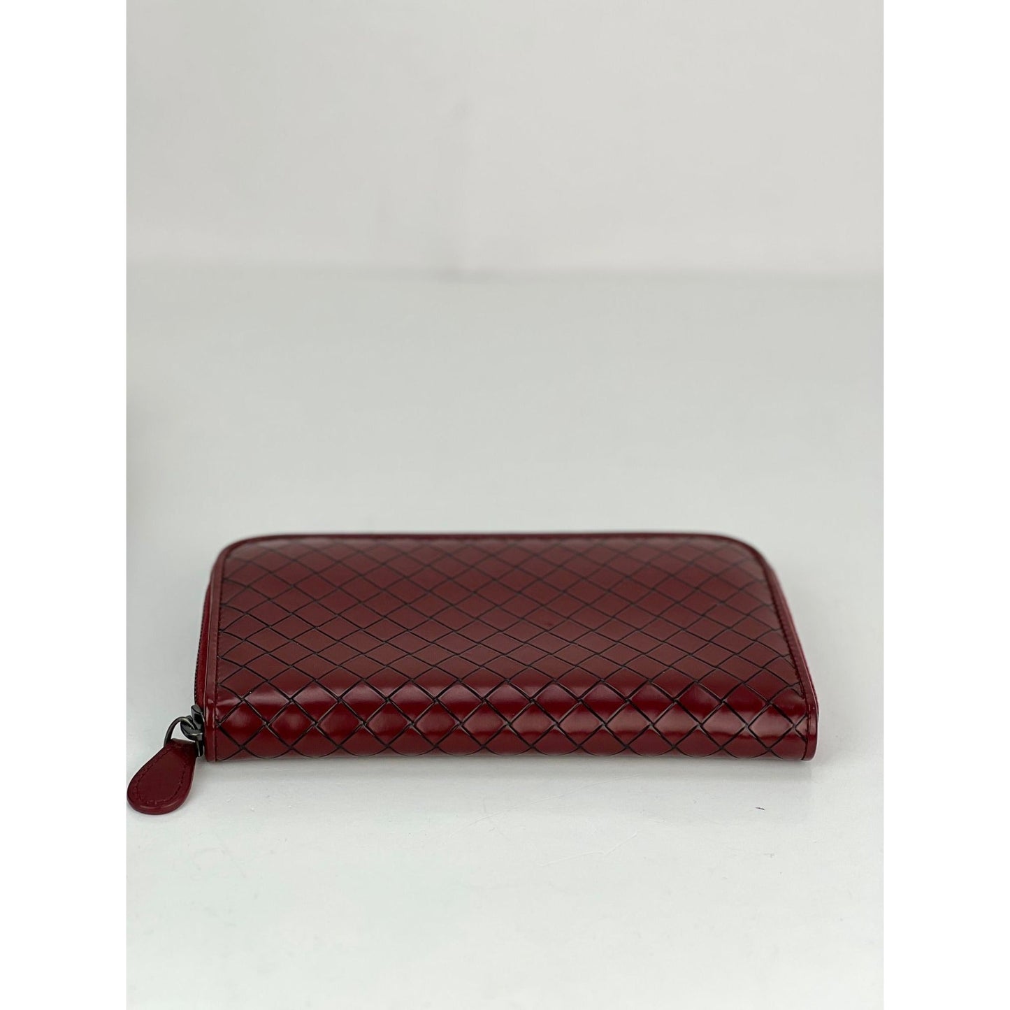 Pochette portefeuille zippée en cuir bordeaux Intrecciato de Bottega Veneta